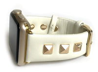 Beautiful CREAM top grain genuine LEATHER, STUDDED Apple Watch Band. This watch band features a stainless steel buckle and is adorned with three metal studs on each side. Stud color choices include Silver, Gold, and Rose Gold. Studs are square shaped and slightly raised in the center giving them a pyramid shape. This watch band fits all series of Apple Watches. Comes in sizes 38/40 and 42/44