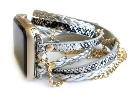 The Boho watch band features three straps on each side of your watch that wrap around the wrist creating the perfect boho style. The three straps include one faux braided leather strap, one gold chain, and one snake print faux leather strap. This boho band has a one size fits all connector fitting watch sizes 38/40/42/44. This band fits wrist sizes 6.25"-7.5" and closes with three different snaps for your custom size