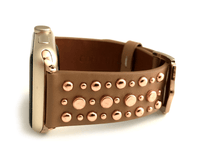 Beautiful TAN top grain genuine LEATHER, STUDDED Apple Watch Band. This watch band features a stainless steel buckle and is adorned with several flat circular studs. Stud color choices include Silver, Gold, and Rose Gold.  This watch band fits all series of Apple Watches. Comes in sizes 38/40 and 42/44