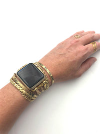 The Boho watch band features three straps on each side of your watch that wrap around the wrist creating the perfect boho style. The three straps include one faux braided leather strap, one gold chain, and one snake print faux leather strap. This boho band has a one size fits all connector fitting watch sizes 38/40/42/44. This band fits wrist sizes 6"-7.5" and closes with three different snaps for your custom size.