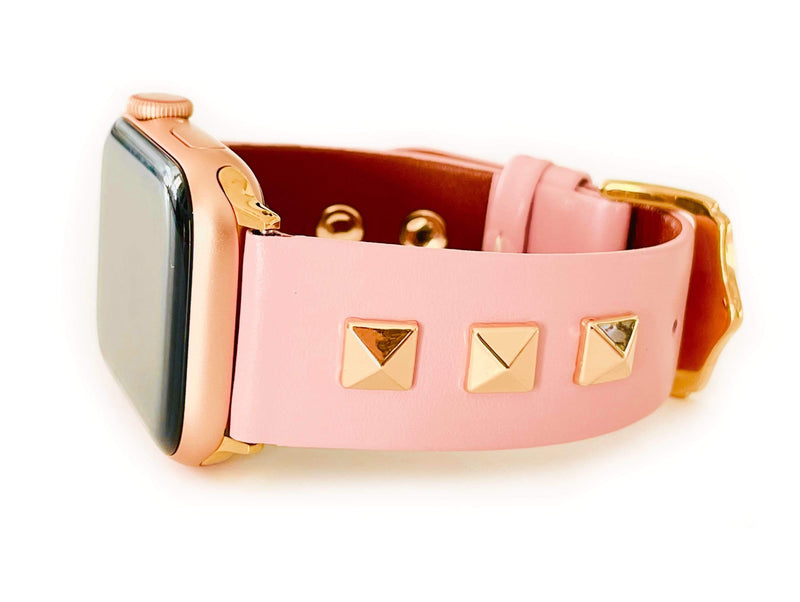 Beautiful PINK top grain genuine LEATHER, STUDDED Apple Watch Band. This watch band features a stainless steel buckle and is adorned with three metal studs on each side. Stud color choices include Silver, Gold, and Rose Gold. Studs are square shaped and slightly raised in the center giving them a pyramid shape. This watch band fits all series of Apple Watches. Comes in sizes 38/40 and 42/44