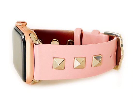 Beautiful PINK top grain genuine LEATHER, STUDDED Apple Watch Band. This watch band features a stainless steel buckle and is adorned with three metal studs on each side. Stud color choices include Silver, Gold, and Rose Gold. Studs are square shaped and slightly raised in the center giving them a pyramid shape. This watch band fits all series of Apple Watches. Comes in sizes 38/40 and 42/44